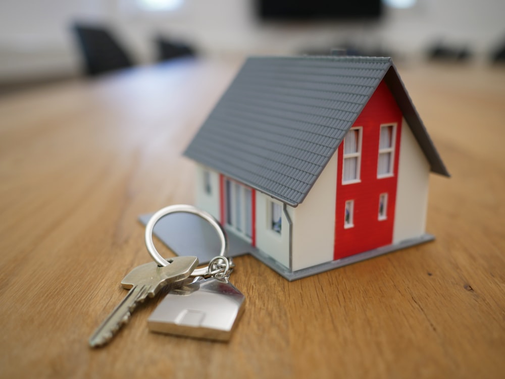 A model house and a set of keys on a table during a homeowner consultation