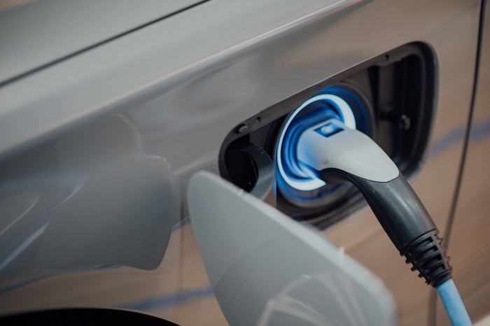 An electric vehicle connected to a charger in the EV service bay